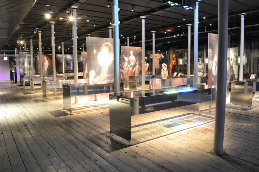 Table cases with mirrored exterior surface and transparent glass. The lace is projected onto the floor.